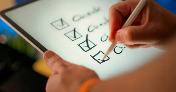 يد تضع علامات على بنود قائمة تحقق